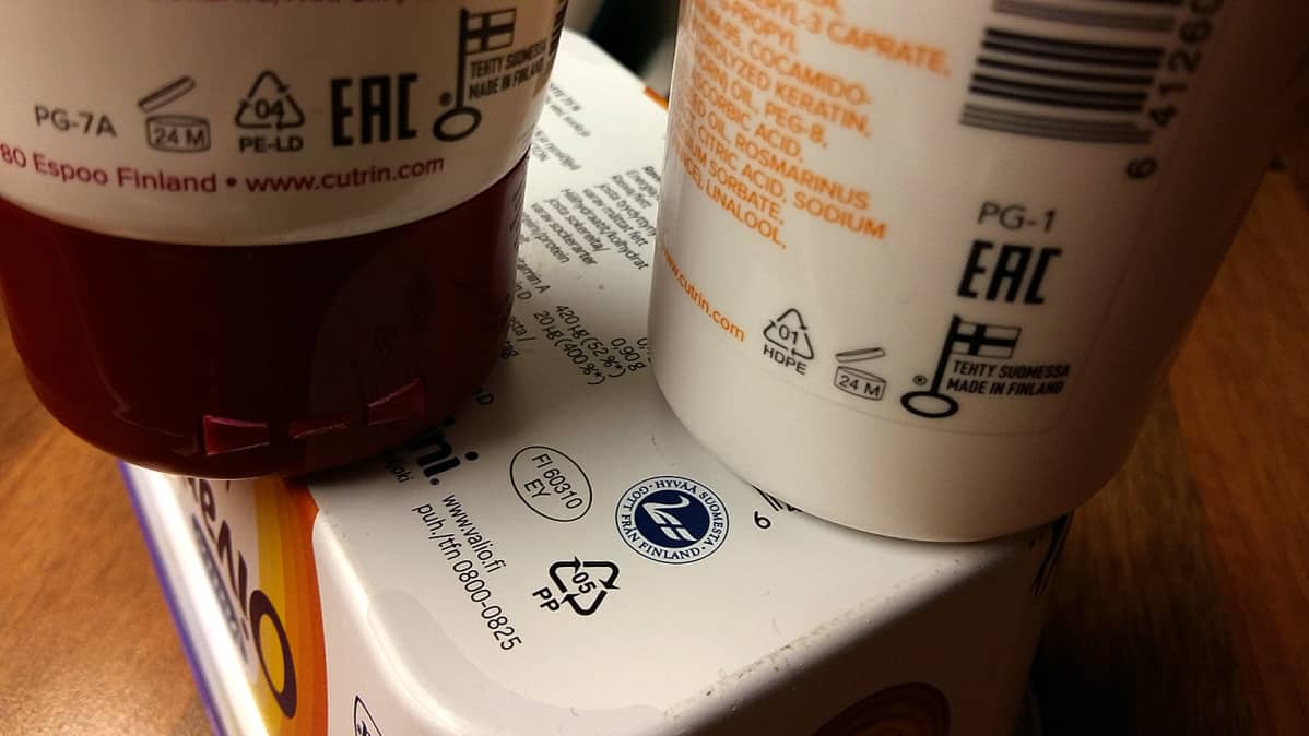 Muovipullot ja voipaketti, joiden muovityyppimerkinnät lähikuvassa