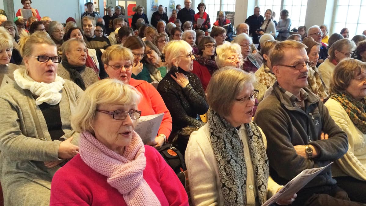 Sali täynnä yleisöä laulamassa vanhoja koululauluja Työväenmuseo Werstaalla Tampereella.