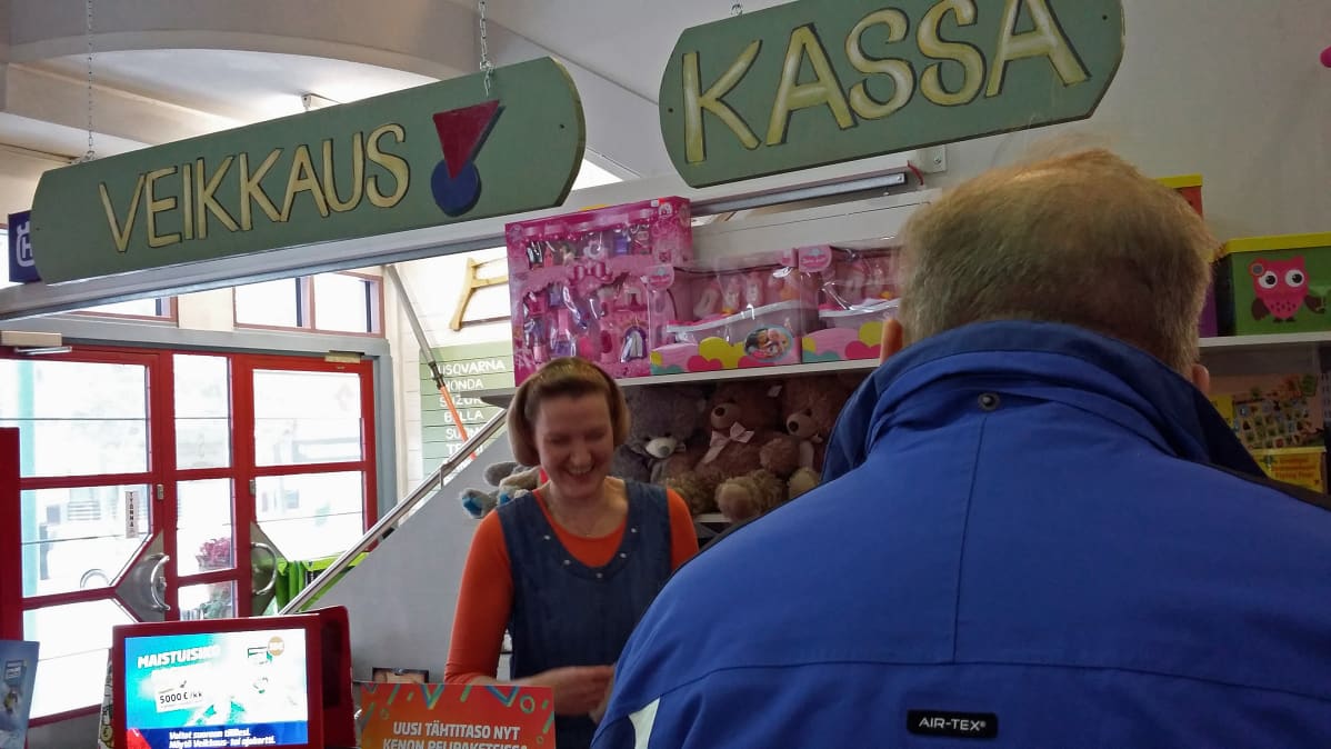 Mies peklaa lottoa Veikkauksen pisteessä.