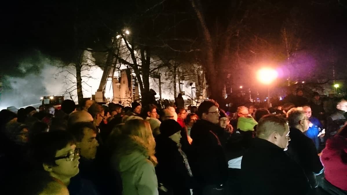 Ihmisiä Ylivieskan palaneella kirkolla 27.3.2016