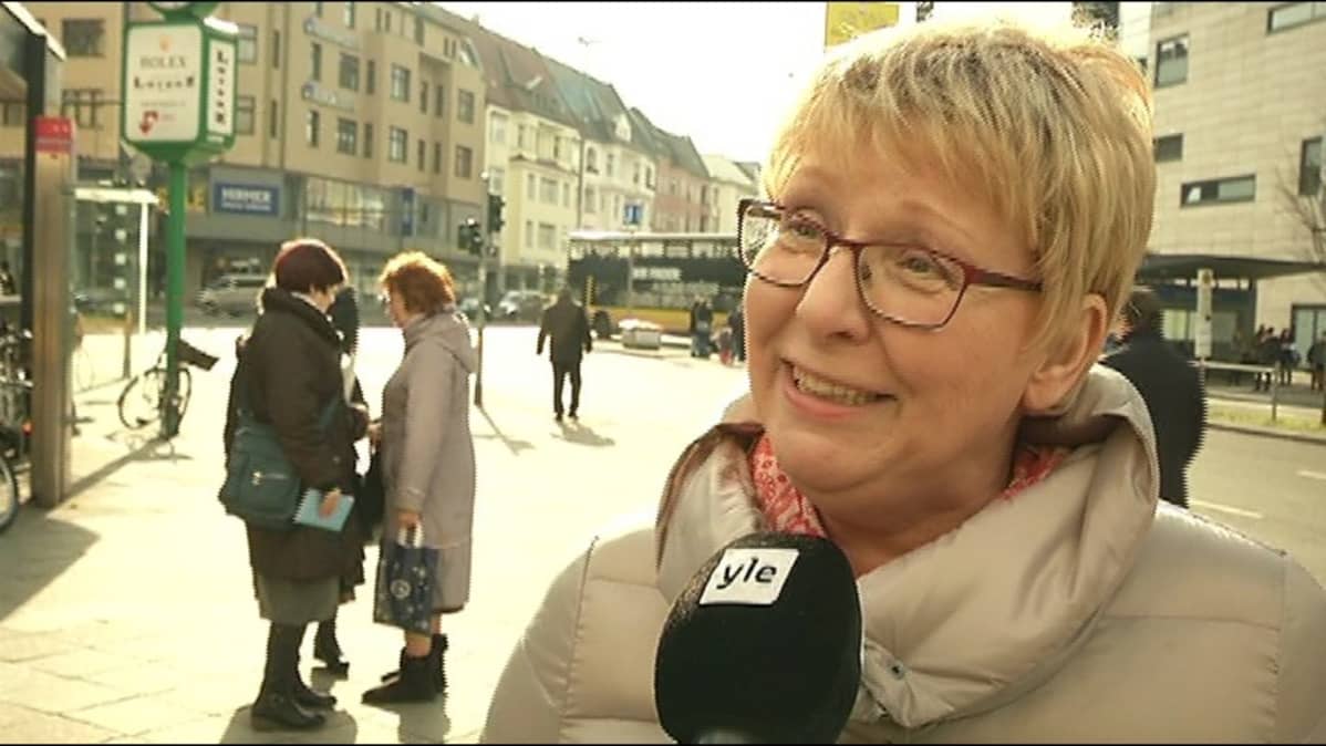 Nainen hymyilee kameralle.