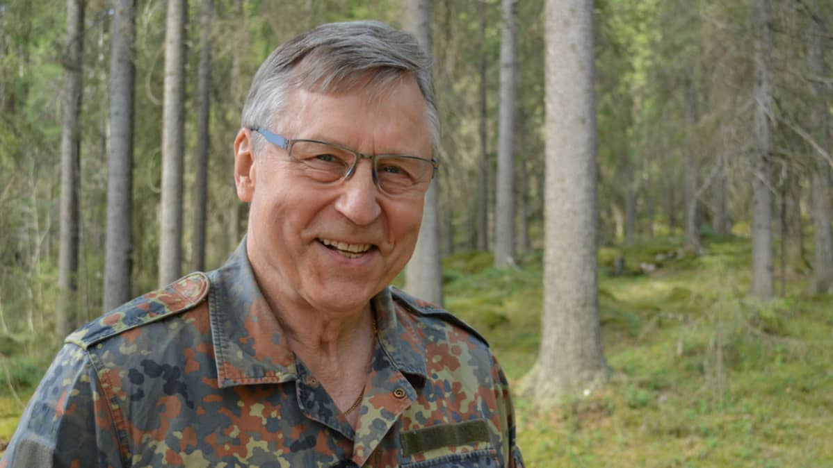 Kansanedustaja Pertti Salolainen metsässä.
