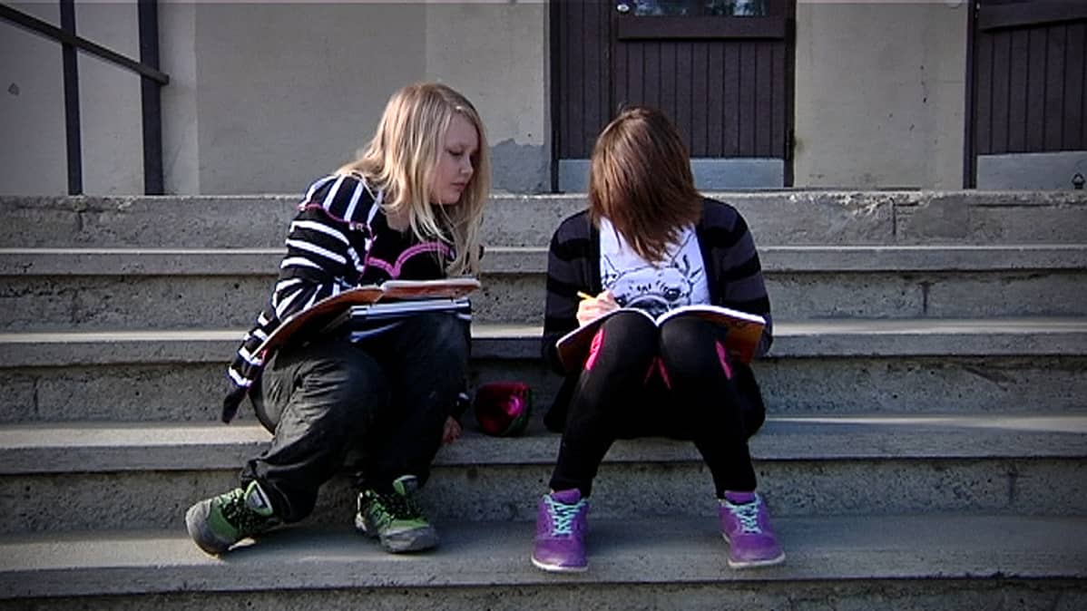 Oppilaita koulun portailla.