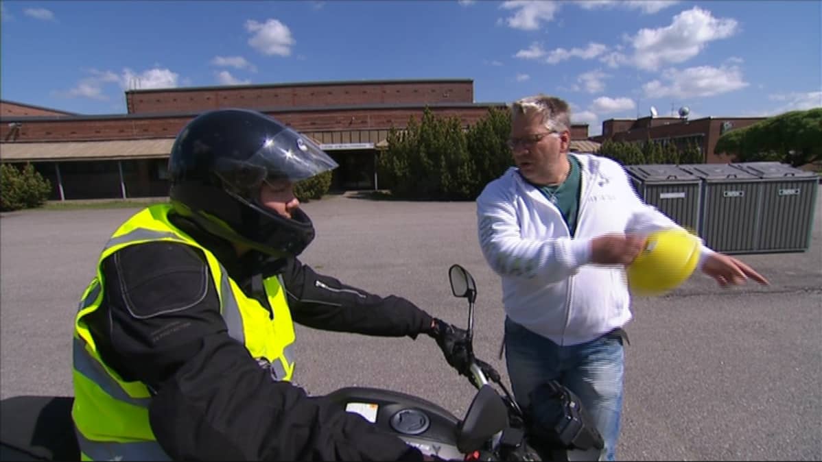 Moottoripyöräilijä ja liikenneopettaja keskustelevat.