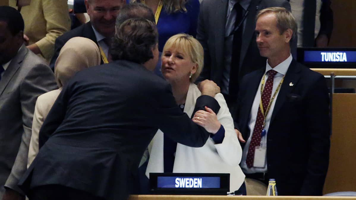 Mies- ja naisvirkamies antavat poskisuudelmaa toisilleen.