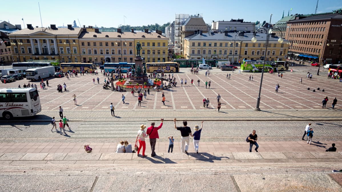 Turistit ottavat ryhmäkuvaa tuomiokirkon portailla.