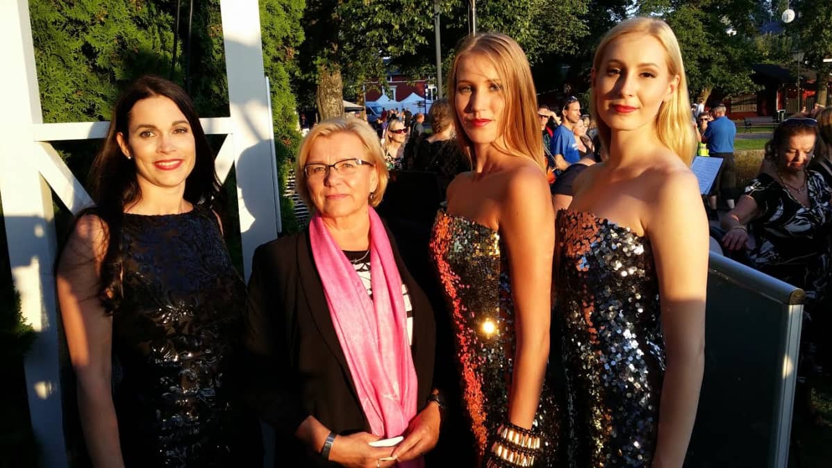 Toimitusjohtaja Tarja Rautiainen mallien kanssa Naantalin rannassa.