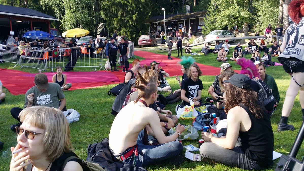 Festariyleisöä viettämässä aikaa nurmella.