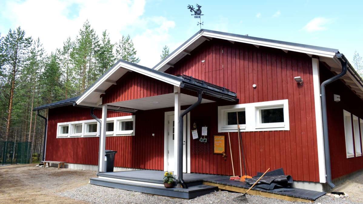 Green care -pieneläinkoti Piispalassa Kannonkoskella. Oranssi kyltti punaisen talon seinustalla.
