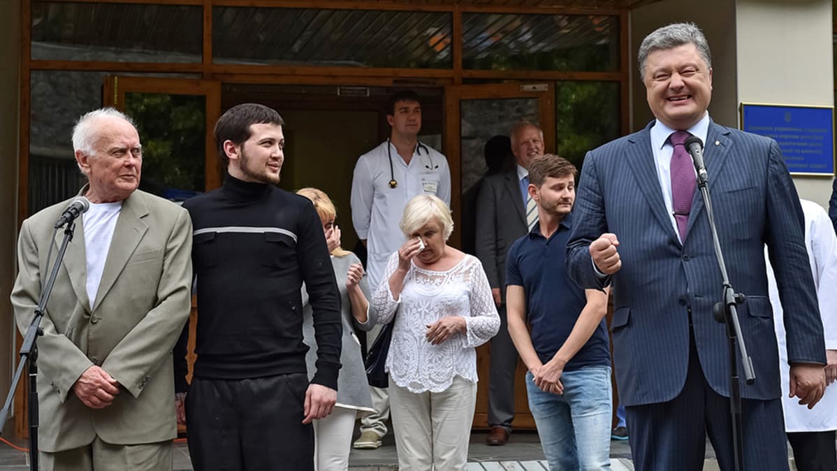 Gennadi Afanasjev ja Juri Soloshenko lehdistötilaisuudessa 14. kesäkuuta Kiovan lentokentällä heidän vapauduttuaan Venäjältä. Ukrainan presidentti Petro Poroshenko osallistui tilaisuuteen.