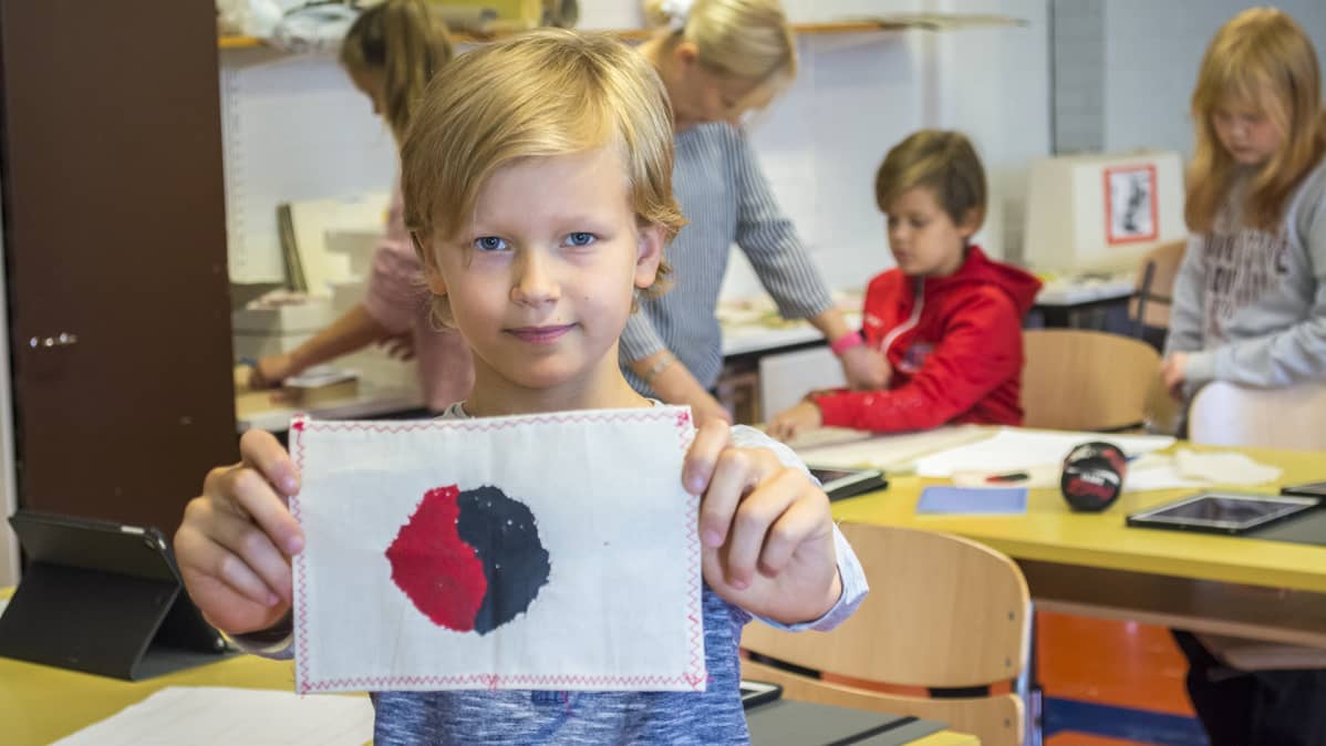Lapsi näyttää tekemäänsä lippua