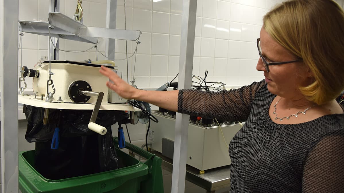 Nainen esittelee biojätteenkäsittelylaitteistoa
