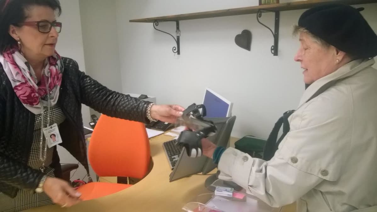 Vanhuspalveluista Päivi Sorsa-Entala ojentaa liukuesteet Riitta Lehtiölle tarkastettuaan tämän iän ja turkulaisuuden.