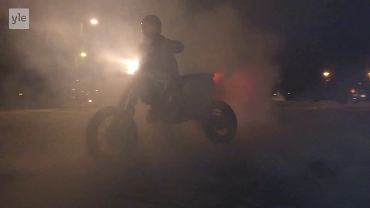 Poika polttaa kumia mopolla