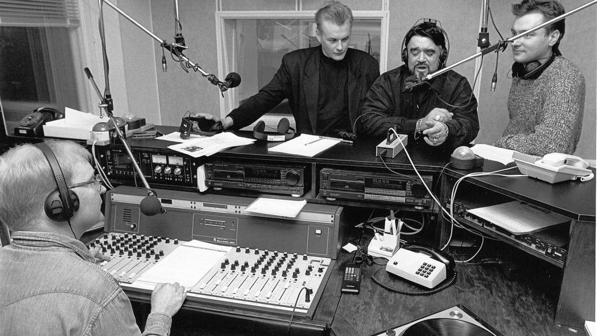 Maailmankuulu radio-dj Wolfman Jack vieraili Radio Jyväskylässä. Jarmo Luukkanen haastattelee. Arto Nyberg ja Eero "Erkku" Hepojoki seuraavat tarkkana.