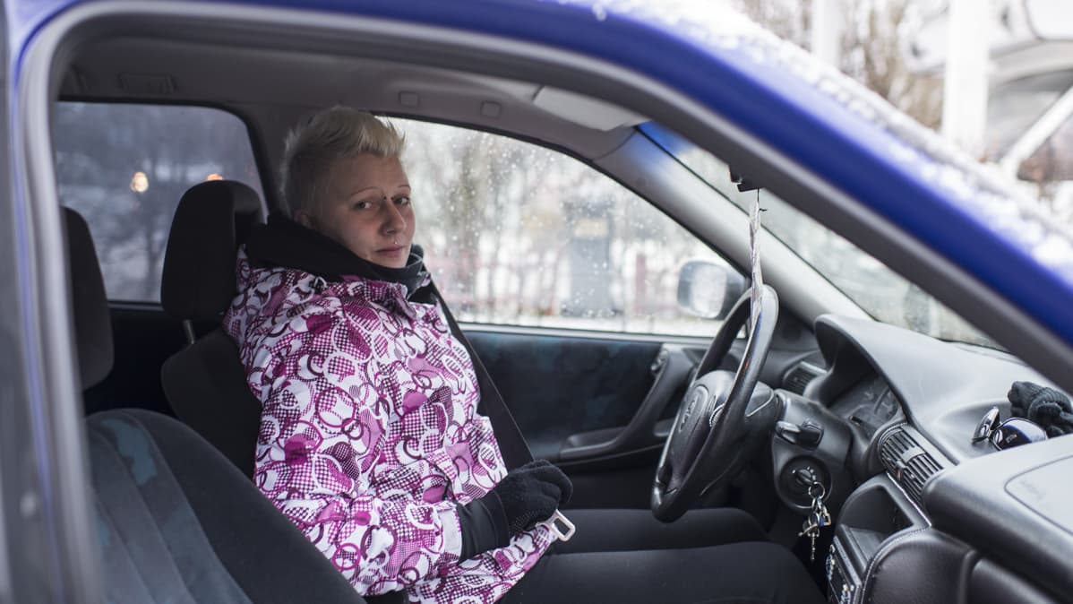 Elina Mäenpää laittaa turvavyötä autossa.
