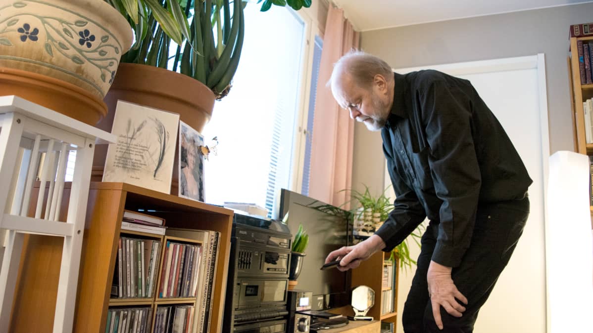 Lasse Lyytikäinen laittaa CD-levyn soittimeen.