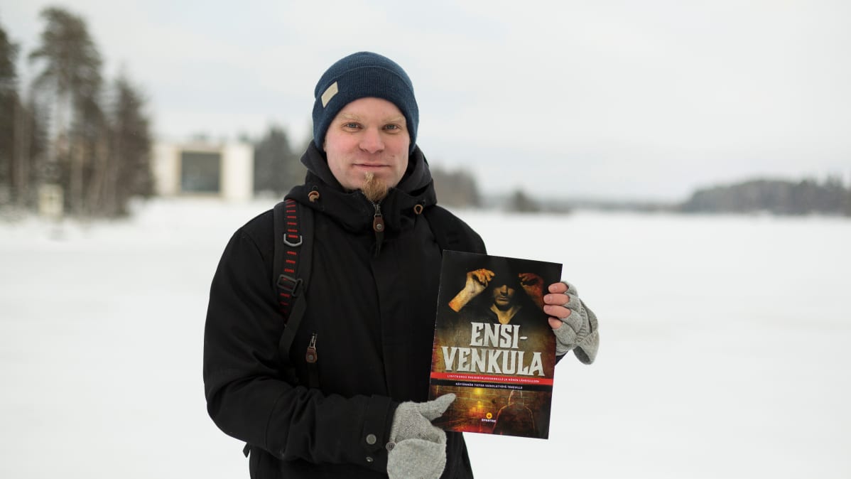 Mies pitää käsissään ensikertalaisvangeille tarkoitettua opasta.