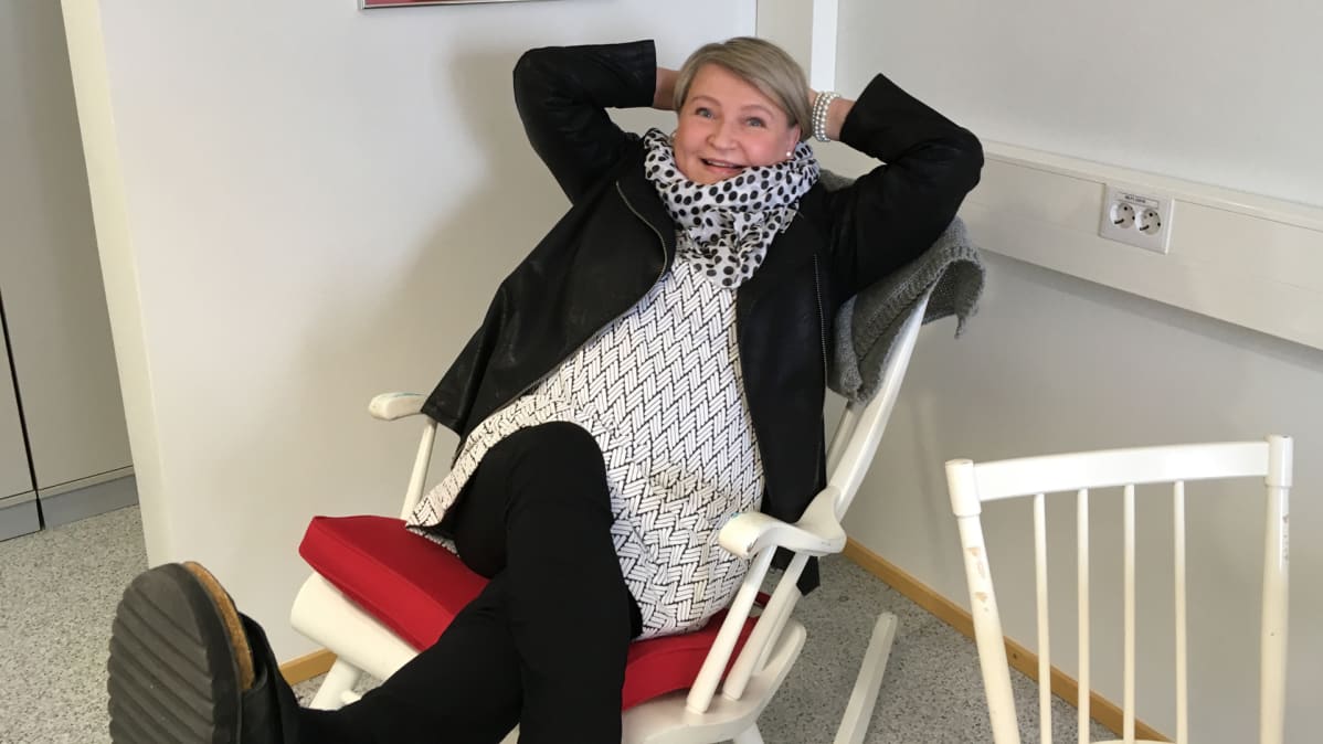 Seija-Sofia Käärmelahti istuu tyytyväisenä keinutuolissa.