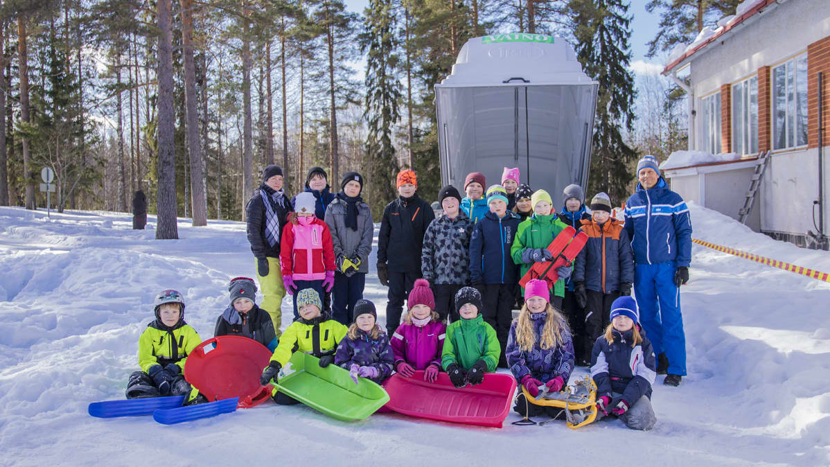 Pohjois-tipaksen koulun oppilaat seisovat liikuntavälinekärryn edessä