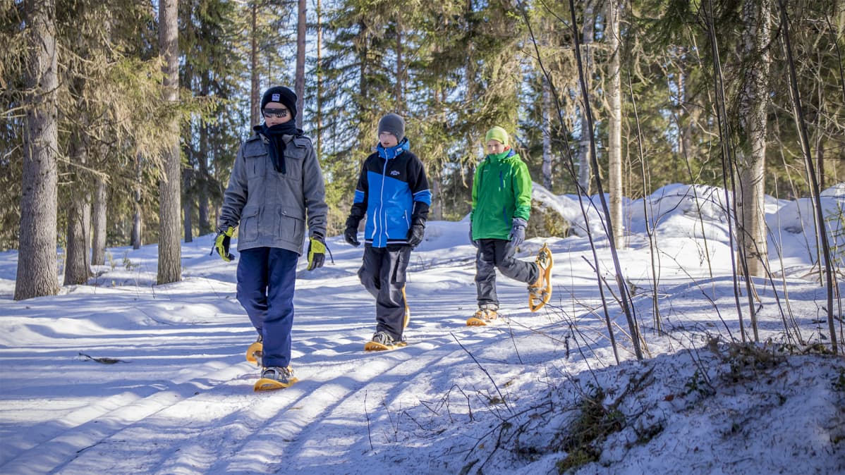 Pohjois-tipaksen koulun oppilaat kävelevät lumikengillä metsässä