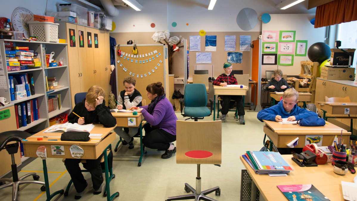 Erityislapsia opiskelemassa koululuokassa.