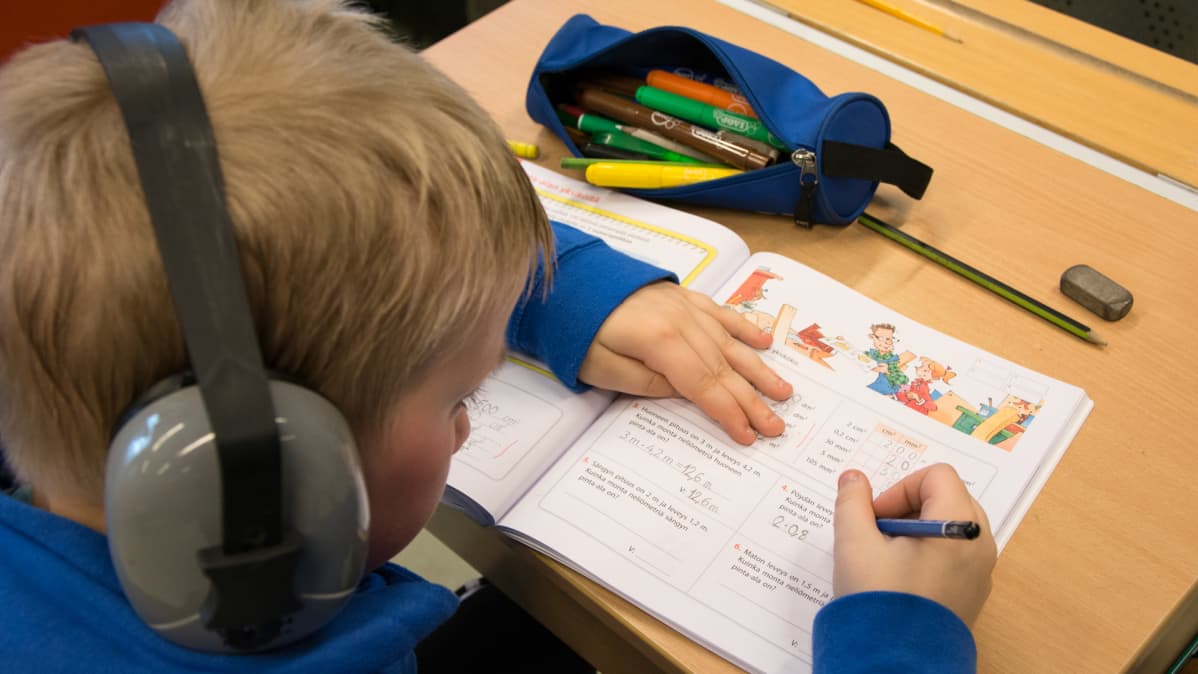 Erityislapsi tekee matematiikan tehtäviä.