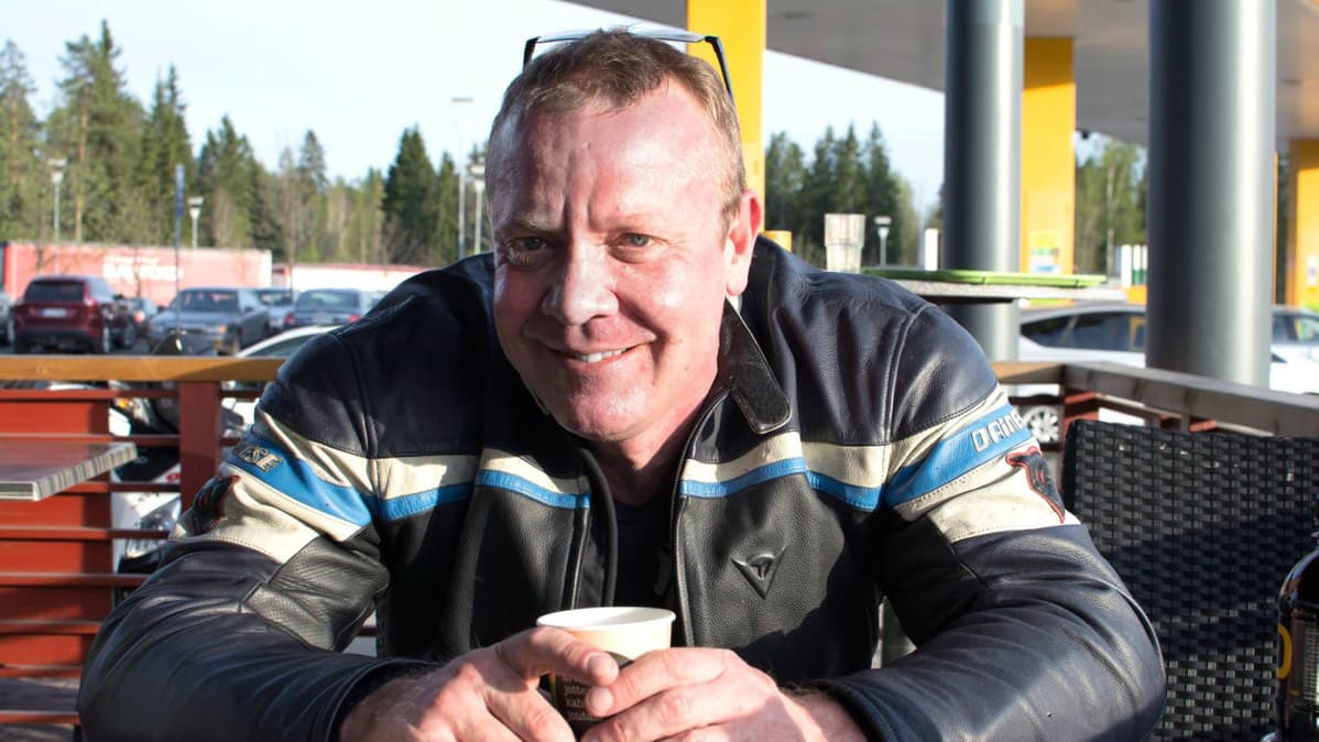 Matti Kannela istuu huolto-asemalla kahvilla