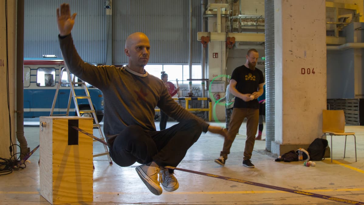 Mies tasapainoilee slacklinellä