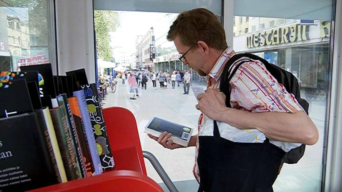 Mies katselee kirjoja.