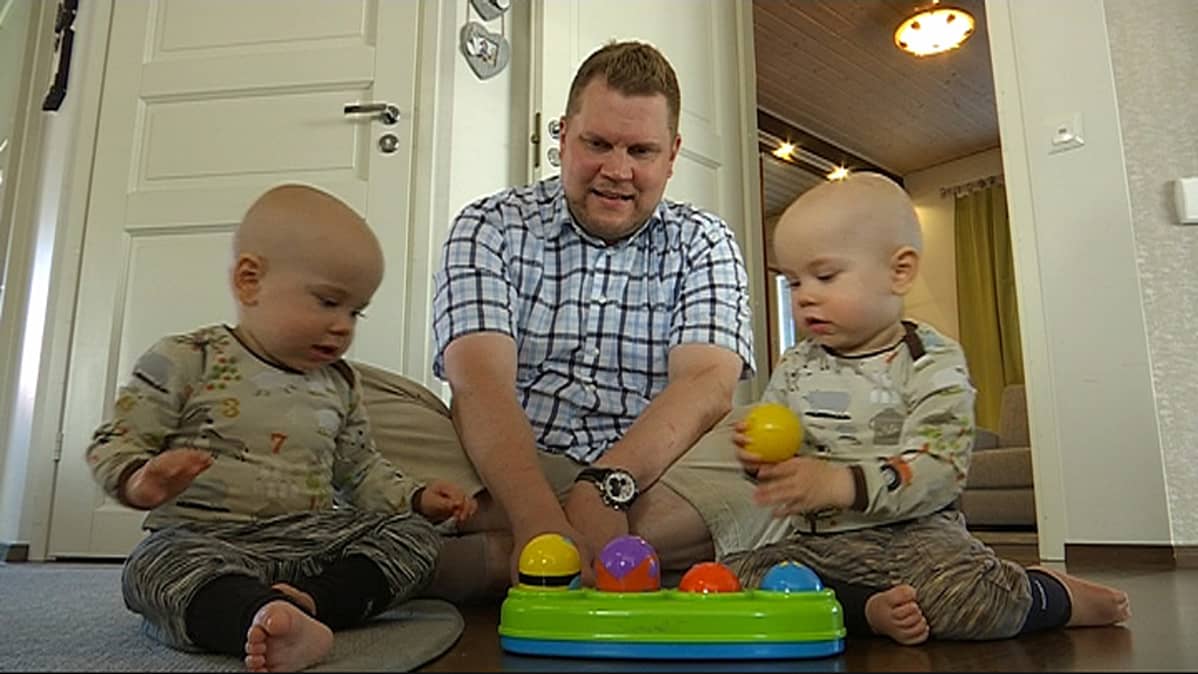 Isä kaksoset sylissään