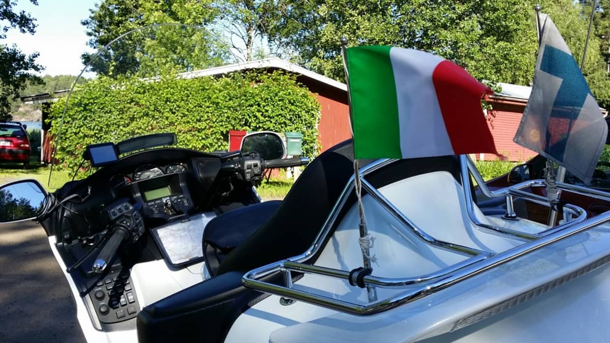 Italian ja Suomen pienoisliput moottoripyörän takana.