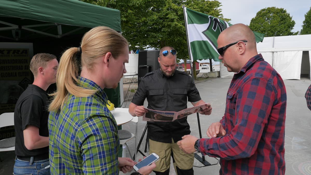 Pohjoismainen vastarintaliikkeen edustajat seisoskelevat teltallaan odottamassa kiinnostuneita.