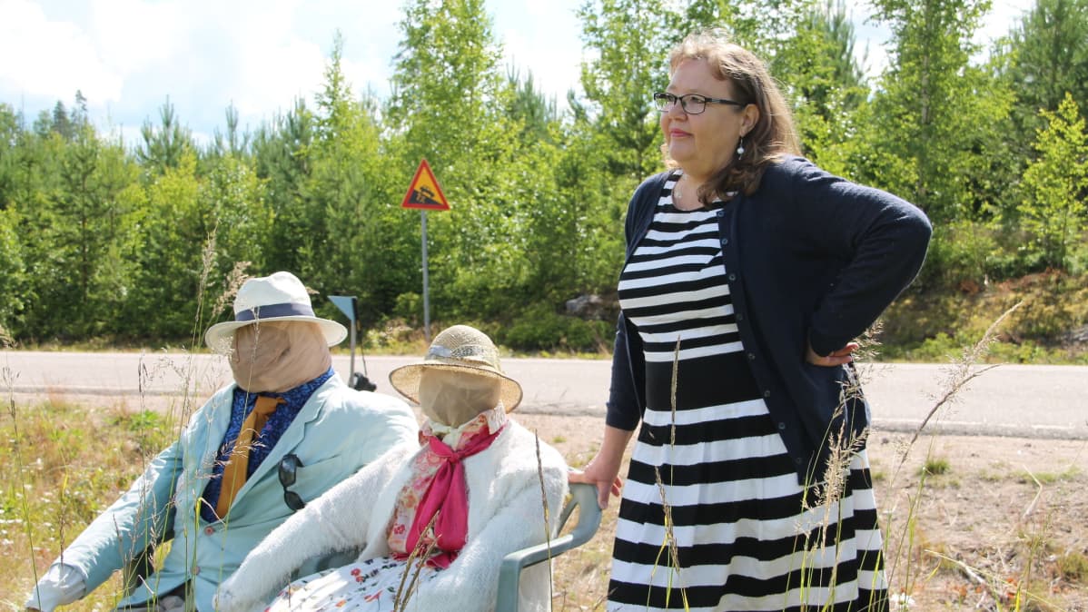 Raija Niemelä heinäukkojen vierellä Jäppilänniemen taidetiellä.