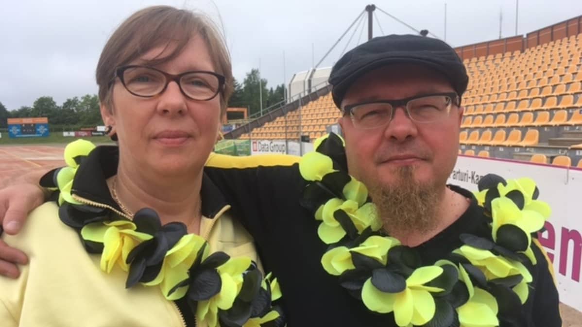 Kouvolan Pallolyöjien pesisfanit Aija Sydänmaanlakka ja Tarmo Aavaluoma leit kaulassa Kouvolan pesäpallostadionilla