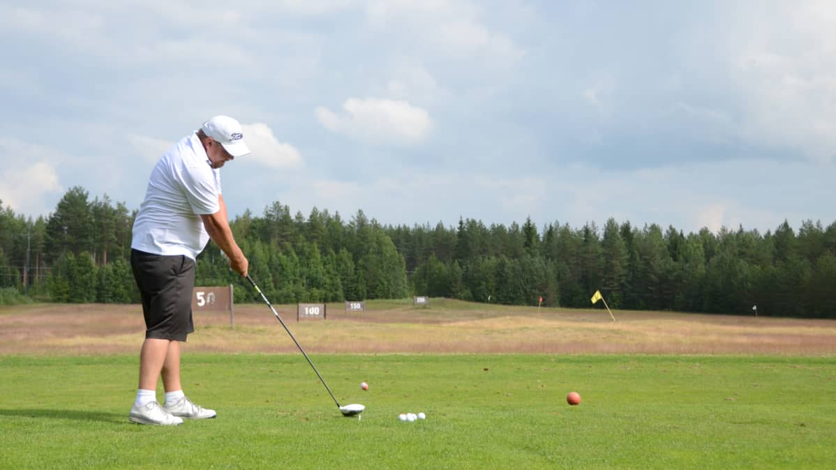 Golfaaja lyö palloa.
