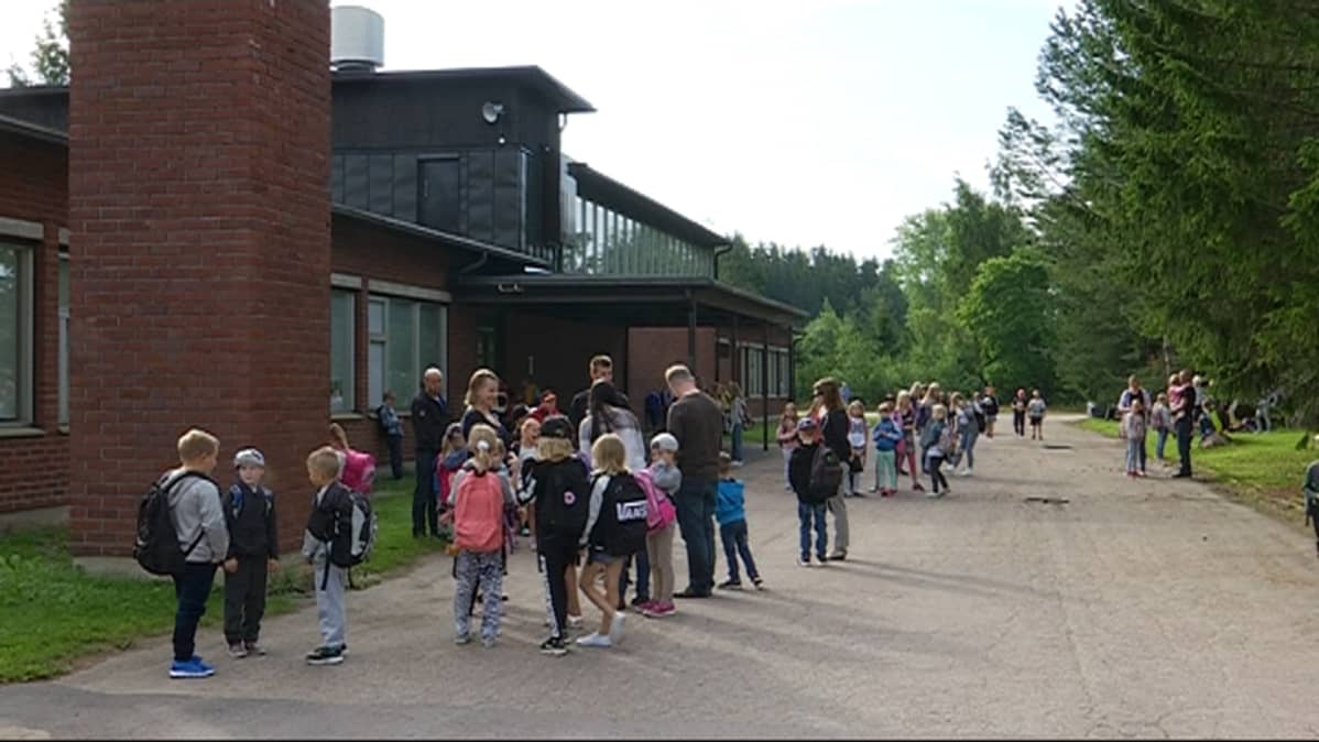 Anjalan koulun oppilaat odottavat koulun pihalla uuden lukuvuoden alkua
