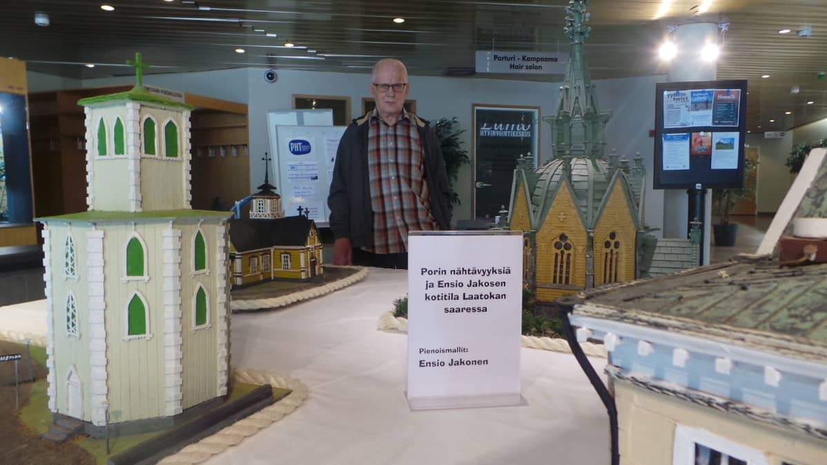 Ensio Jakonen rakentamiensa pienoismallien vieressä