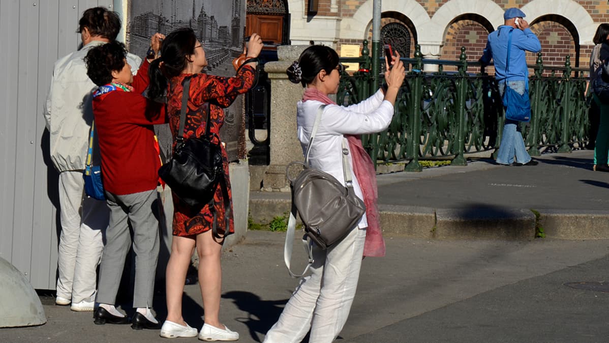 Kiinalaiset turistit ottavat valokuvia.