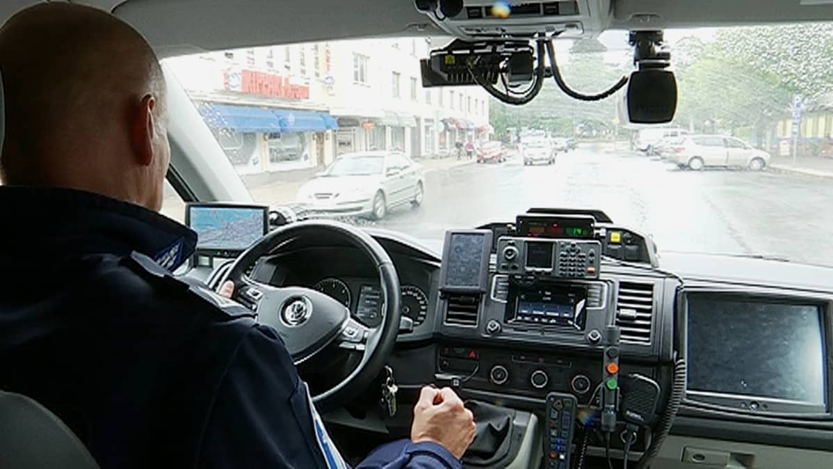 Poliisi ajaa poliisiautolla.