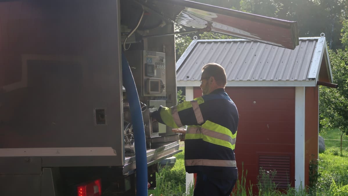 Kari Takala laittaa maitonäytteen auton kaappiin