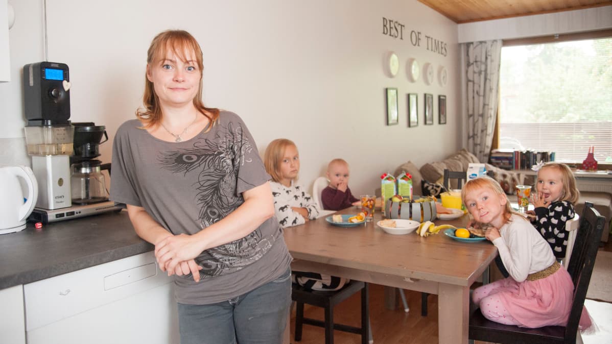 Äiti lasten kanssa keittiössä.