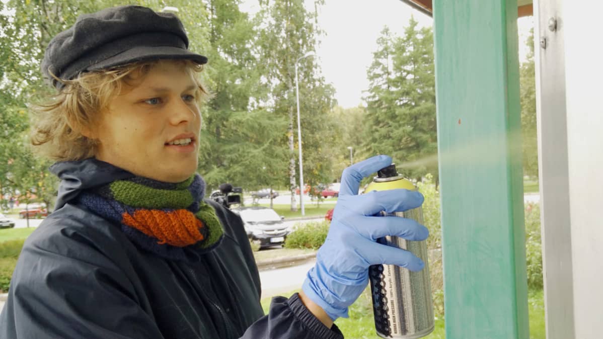 Katutaiteilija Tommi Pasanen työn touhussa.