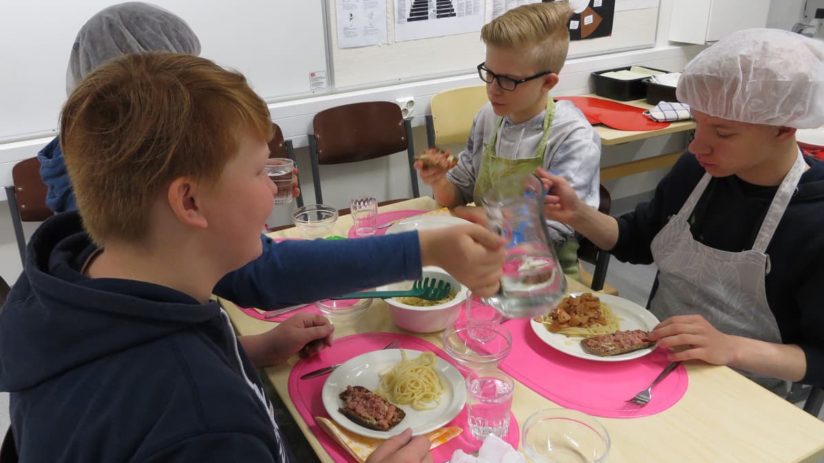 Kahdeksasluokkalaiset pojat maistelevat kotitaloustunnilla kokkaamiaan ruokia