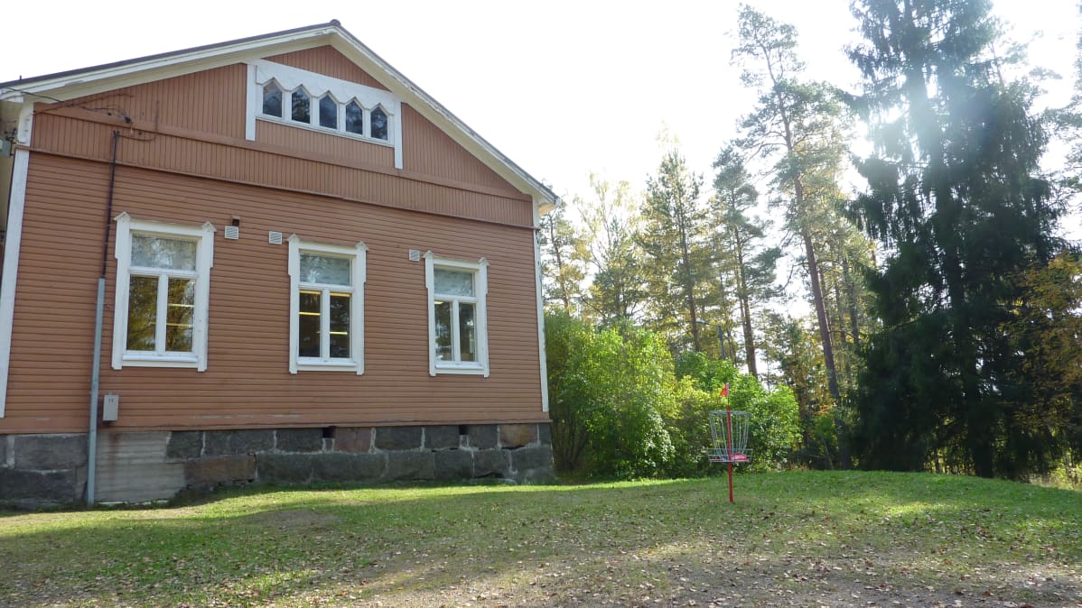 Simolan koulun pihalla näkyy frisbeegolfradan väylä.