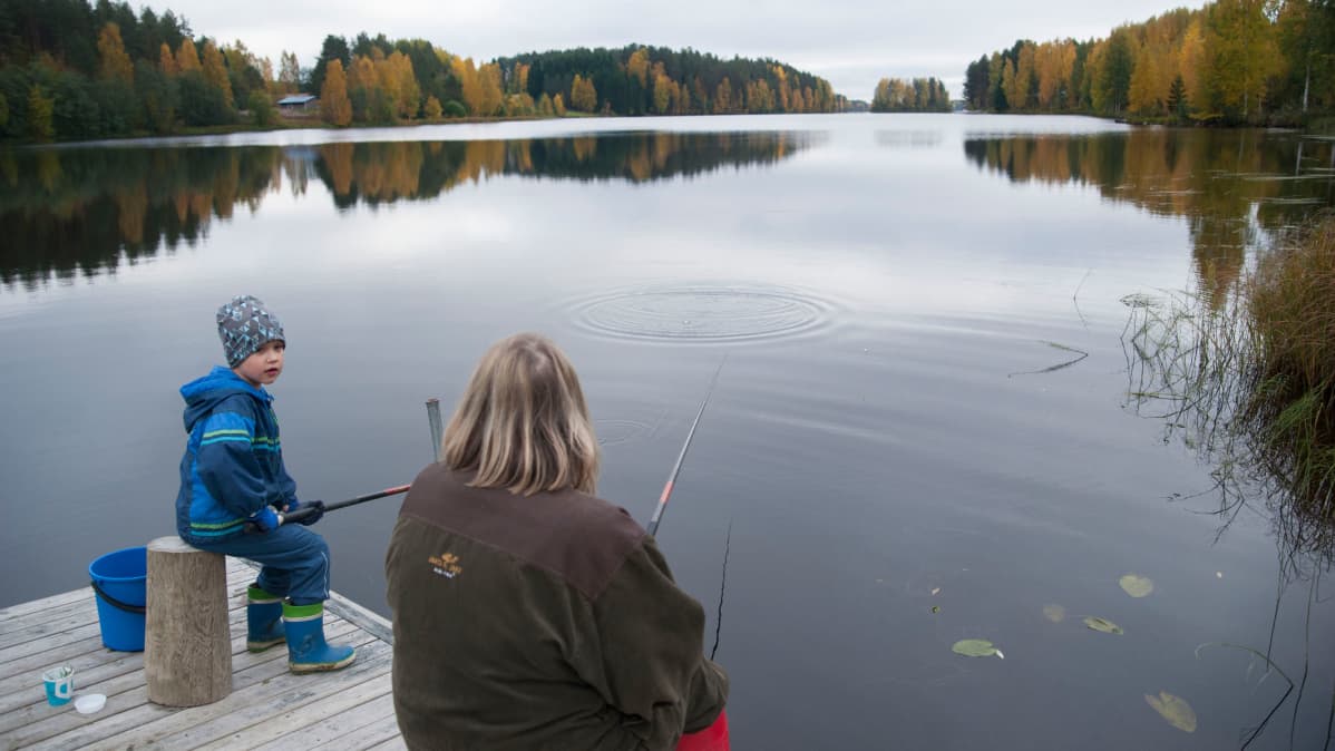 Topias Jaakkola onkii mumminsa kanssa laiturilla.