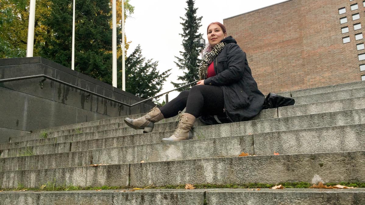 nainen istuu rappusilla