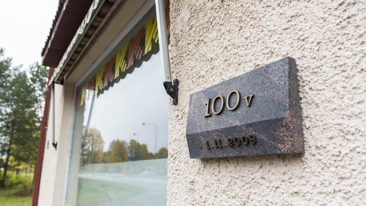 Plakaatti Hyryn kaupan oven vieressä joka kertoo kaupavan olevan yli sata vuotta vanha.