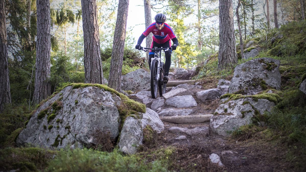 Mies pyöräilee XCO-radalla.