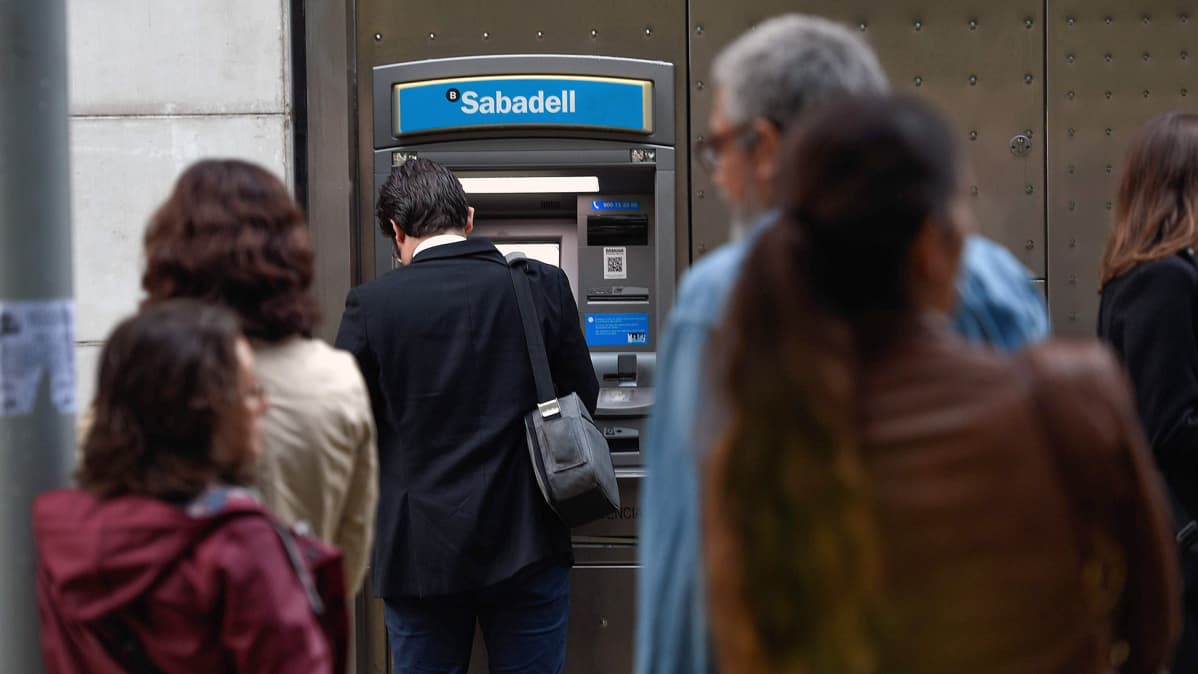 Ihmisiä pankkiautomaatilla Barcelonassa.